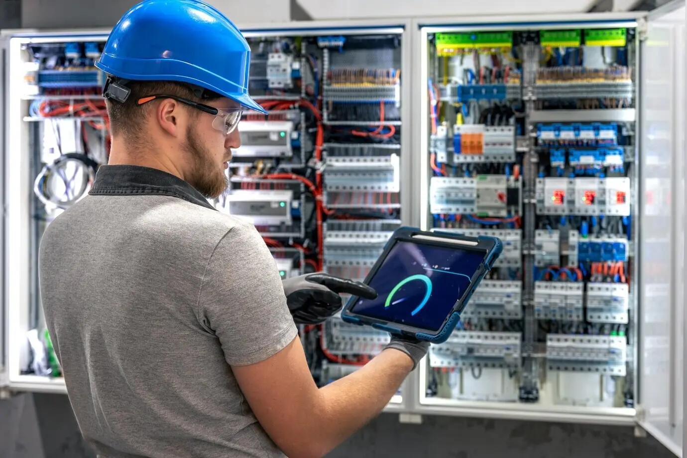 Elektriker vor Ort mit Tablet zur digitalen Steuerung, professioneller Techniker.